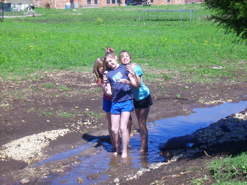 Hannah, Taylor, and Holly posing in the creek