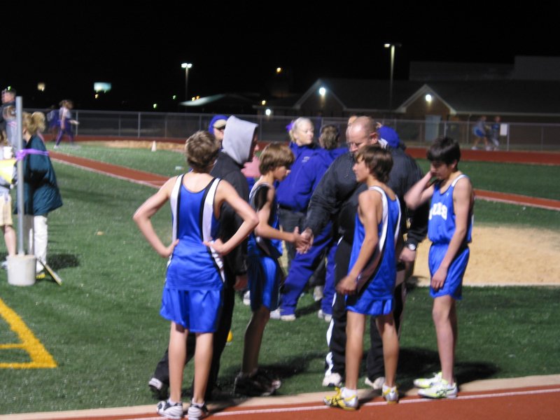 Andrew is congratulated by the coach after his mile run